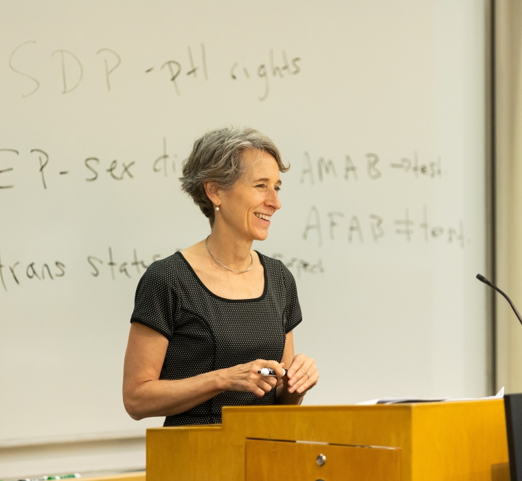 Clare Huntington behind podium and in front of a whiteboard