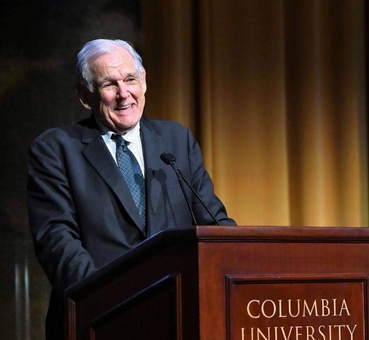 Professor George Bermann in suit and tie speaking in front of a Columbia University podium