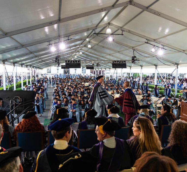 A graduate shakes hands with Dean Abebe at the Class Day ceremony