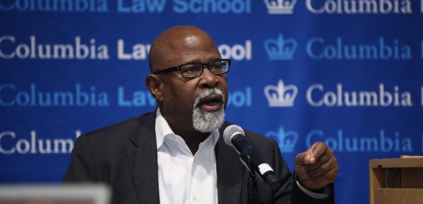 Columbia Law Professor Kendall Thomas in glasses and white shirt in front of mircrophone