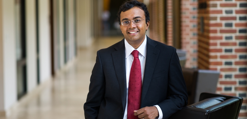 Law professor in black suit and red tie