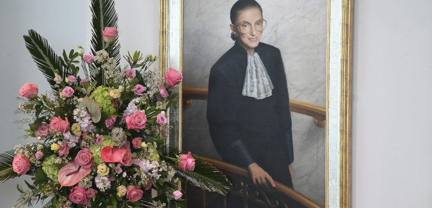 Flowers in front of a portrait of Ruth Bader Ginsburg.