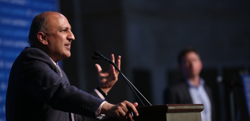 Man speaking and gesturing at podium