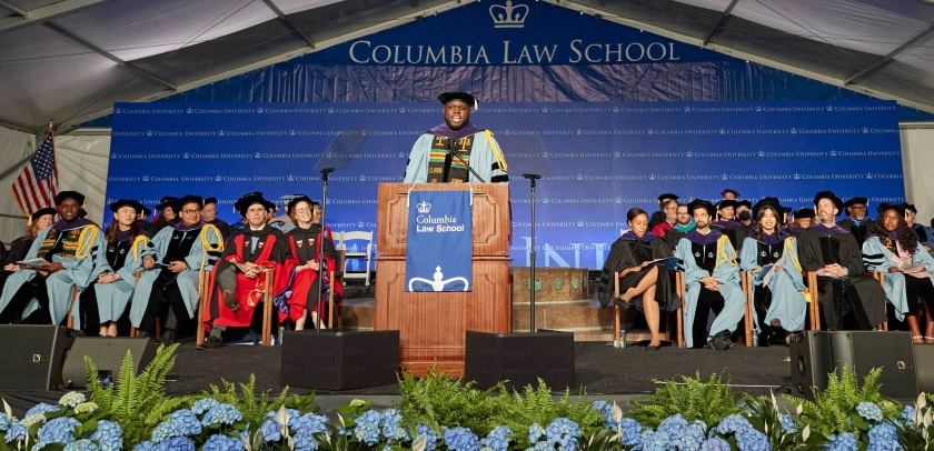 Stage of Columbia Law graduation with hydrangeas and dignitaries