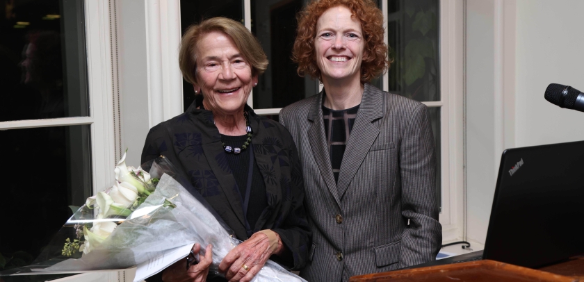 Two women smiling, one with bouquet of flowers