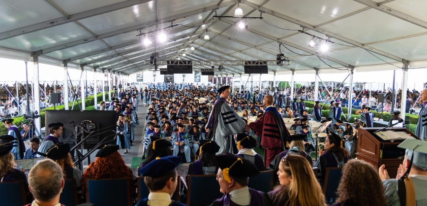 A graduate shakes hands with Dean Abebe at the Class Day ceremony