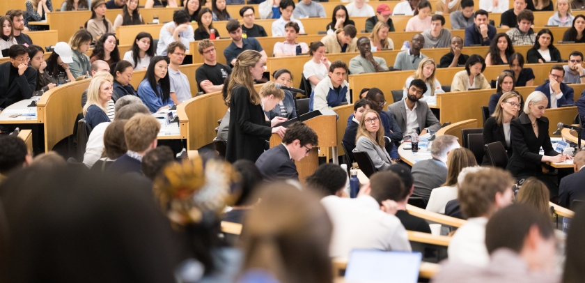 A student at the podium surrounded by fellow students, faculty, and family watching the 2026 Harlan Fiske Stone Moot Court finals.