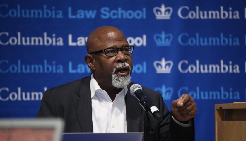 Columbia Law Professor Kendall Thomas in glasses and white shirt in front of mircrophone