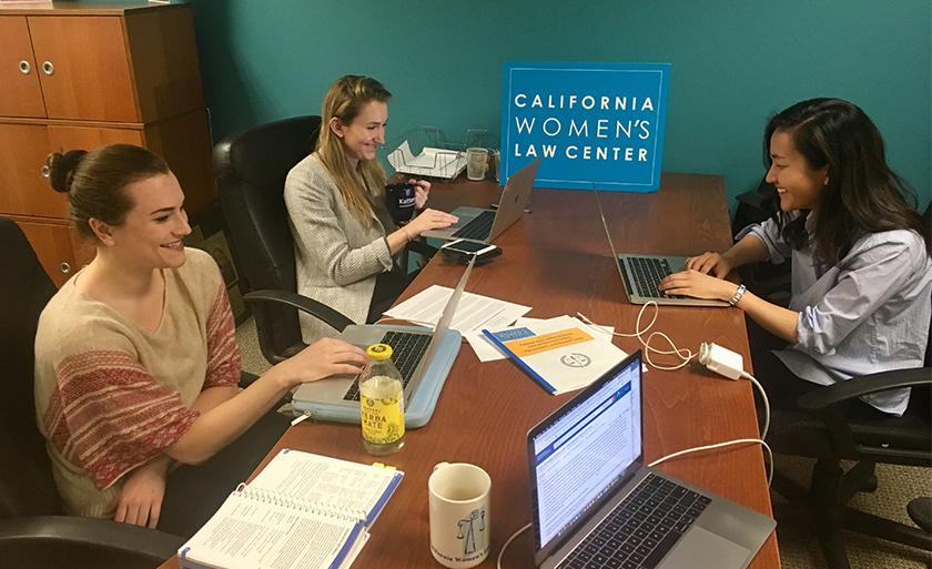 Students smile while work on laptops at the California Women's Law Center.