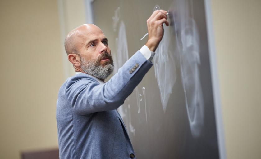 Professor Ed Morrison writing on a chalkboard