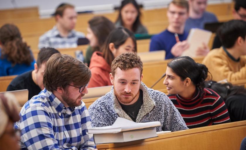 Students looking at a textbook in class