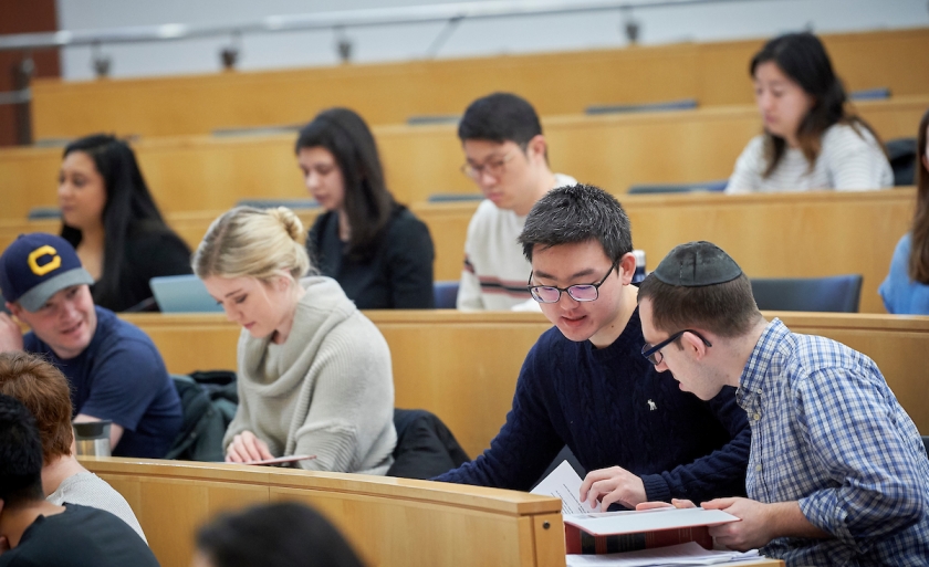 students looking over papers in classroom