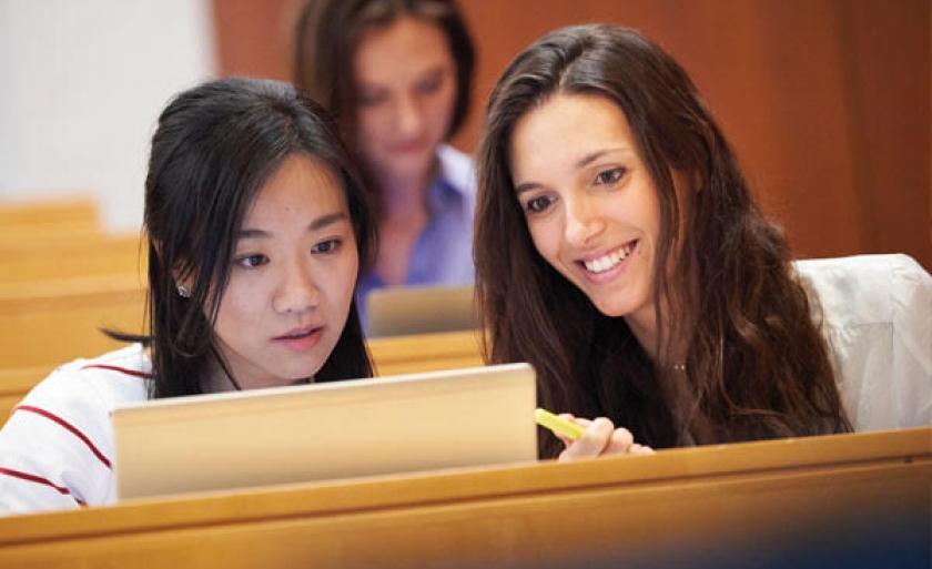 Female students gather around a computer