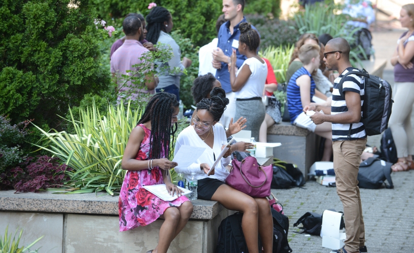 Students sit on Revson Plaza during Orientation