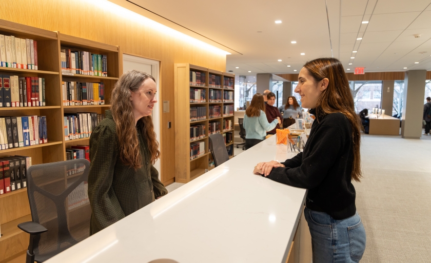 Two women talking on either side of a counter