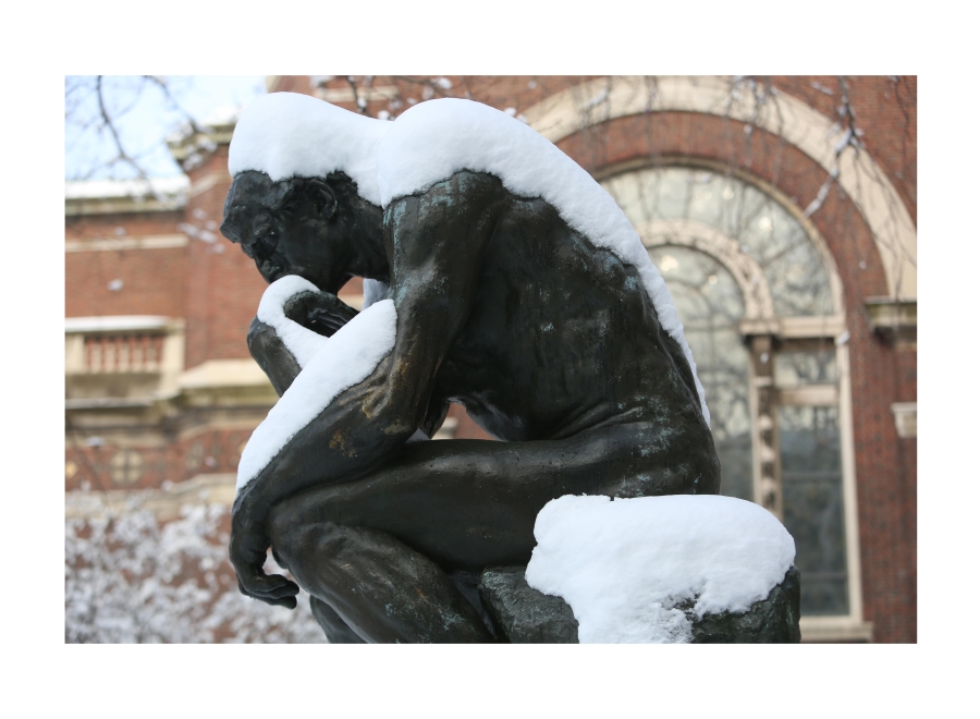 The statue Thinker covered in snow