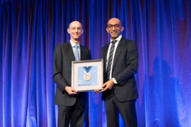 David Greenwald ’83 with Dean Abebe, holding framed medal