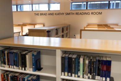 Bookshelves and desks in front of sign that reads "The Brad and Kathy Smith Reading Room"