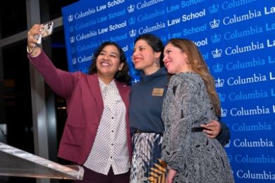 Three women at Columbia Law Alumni of Color Reception taking a selfie in front of Columbia Law School banner.