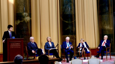 Panel speakers sitting in armchairs on a stage