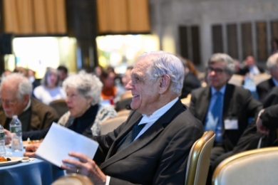 George Bermann sitting at a table with a program in his hand