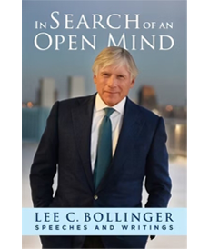 The cover of Lee C. Bollinger’s book “In Search of an Open Mind: Speeches and Writings.” There is a photo of Bollinger in a suit with the backdrop of New York City behind him.