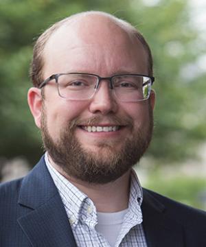 A close-up portrait of a smiling Professor Kellen Funk