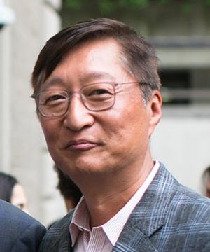 Jeong-Ho Roh '88 smiles outside the law school, wearing a grey suit