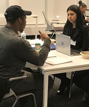 Sharanjit Sandhu ’19, right, meets with a client during the Entrepreneurship and Community Development Clinic’s pop-up legal clinic to help him formalize his food business.