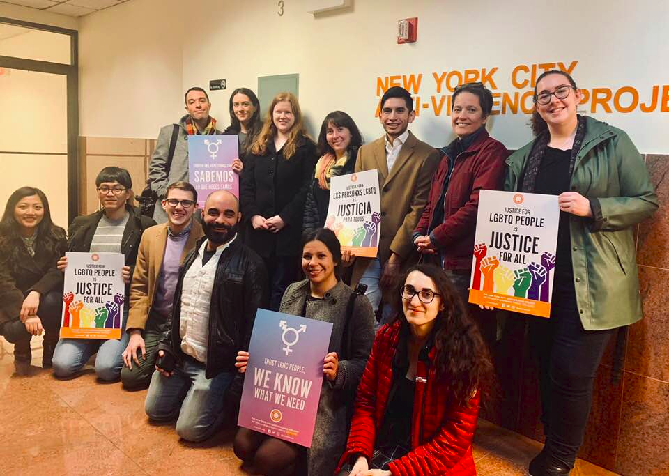 Students pose with rainbow colored placards.