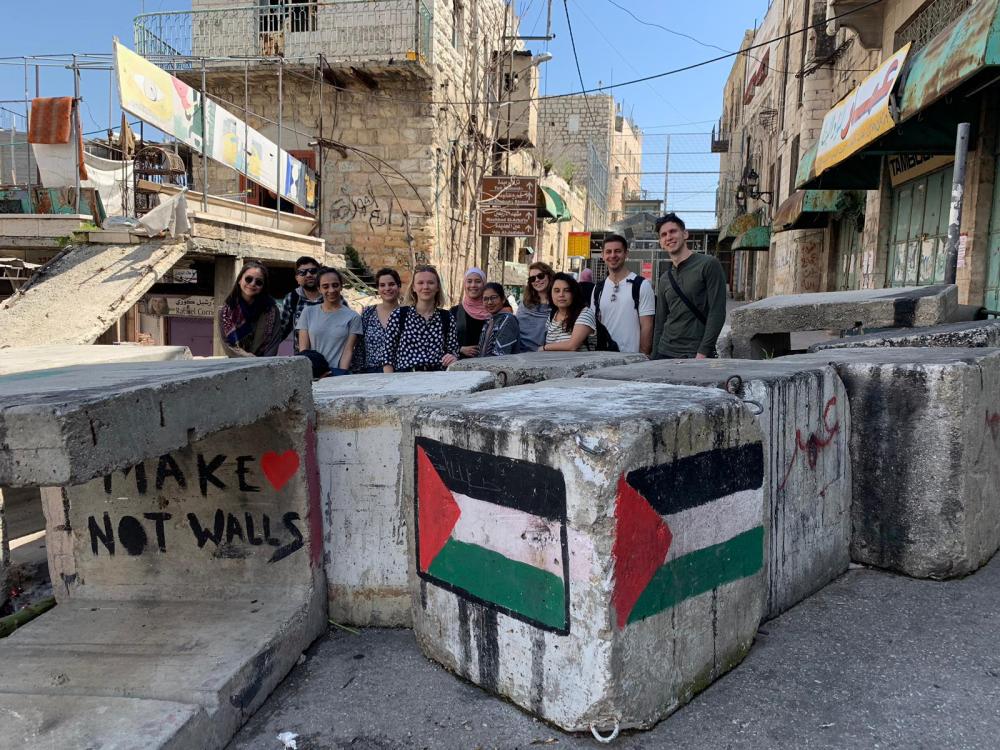 Students stand behind a barricade of cement blocks.