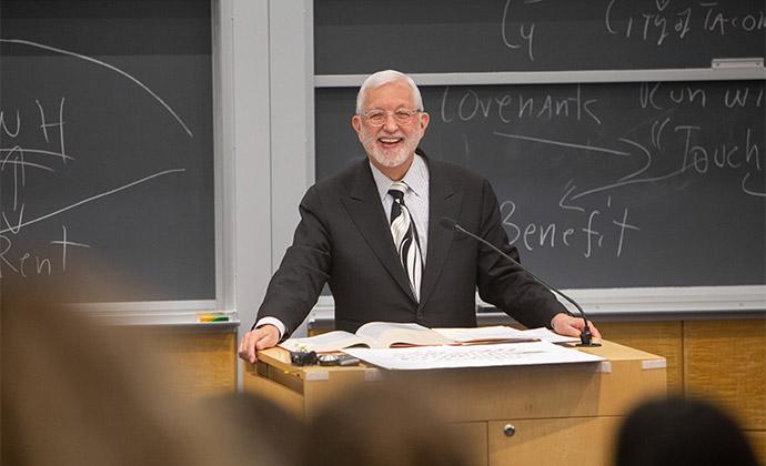 Professor Jed Rakoff smiles, standing behind a podium.