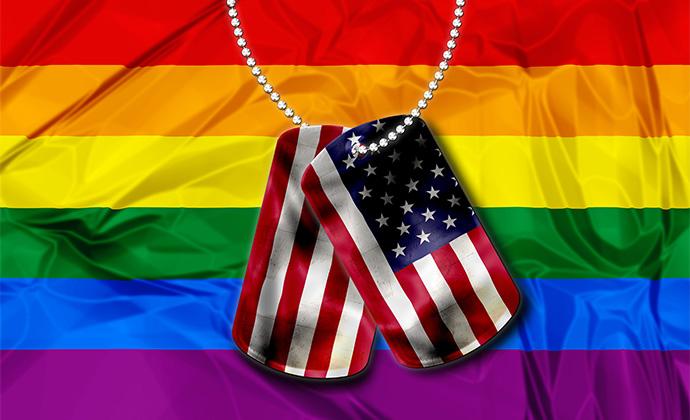 Dog tags with the American flag colors on them hang in front of a rainbow Pride flag.