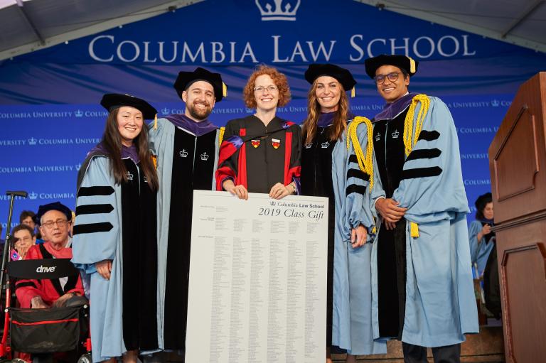 Jessica Choi ’19, Patrick Waldrop ’19, Marie-Marie de Fays, L.L.M. ’19, and Rishabh Devan Parikh ’19 LL.M. present Dean Lester with a scroll listing the class gift conributors.