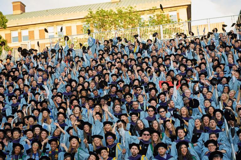 Students toss their mortarboards after graduation.