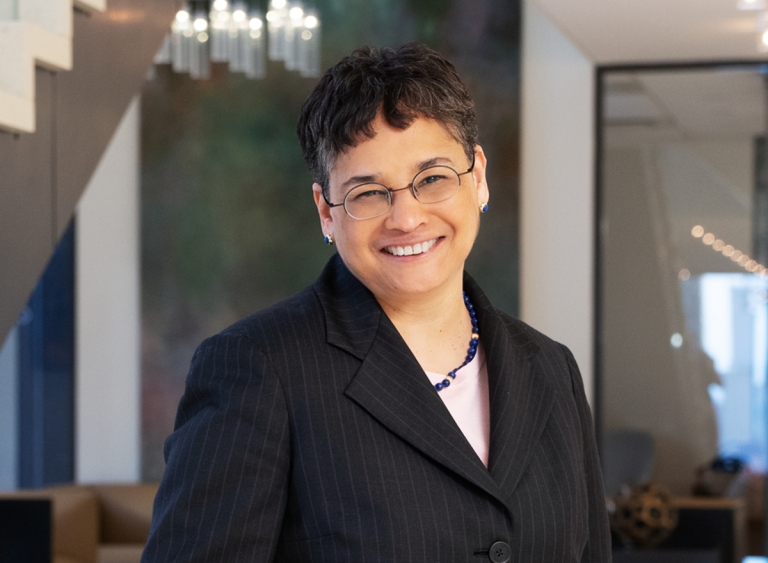 Headshot of woman with glasses in black jacket