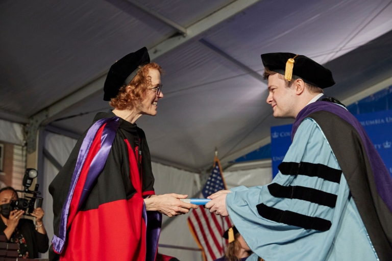 Woman in red and black gown and cap with man in blue and black gown and cap