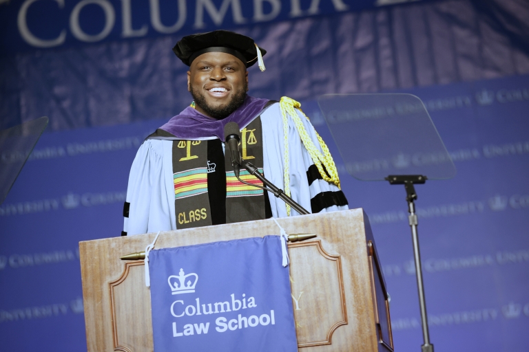 Man in cap and gown at Columbia Law School podium
