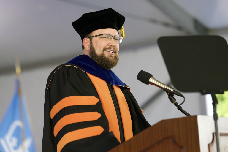 Man in academic regalia at podium 