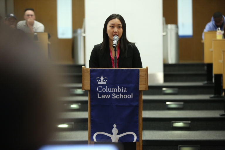 A woman stands at a podium