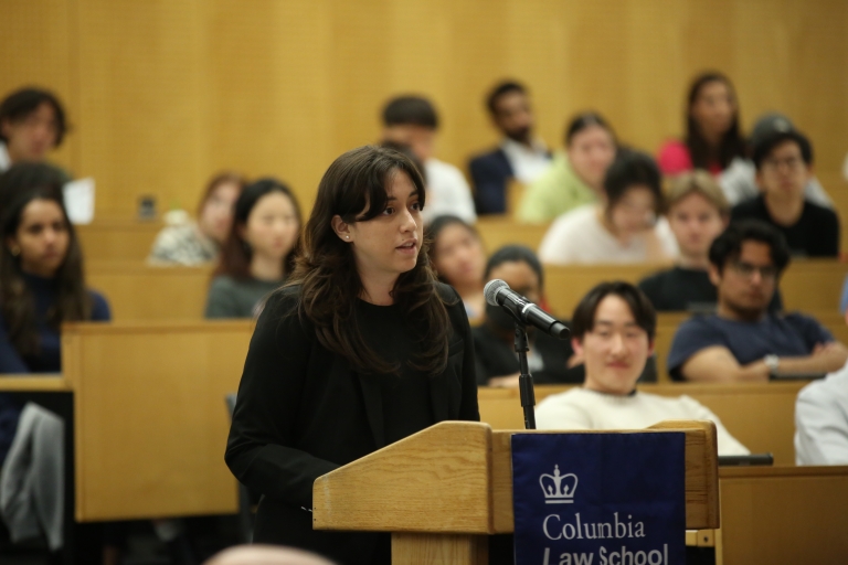 A woman stands at a podium