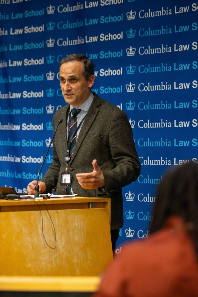 Frédéric Mégret, McGill University Faculty of Law, speaks at a podium.
