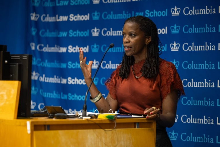 Olatunde Johnson speaks at a podium.