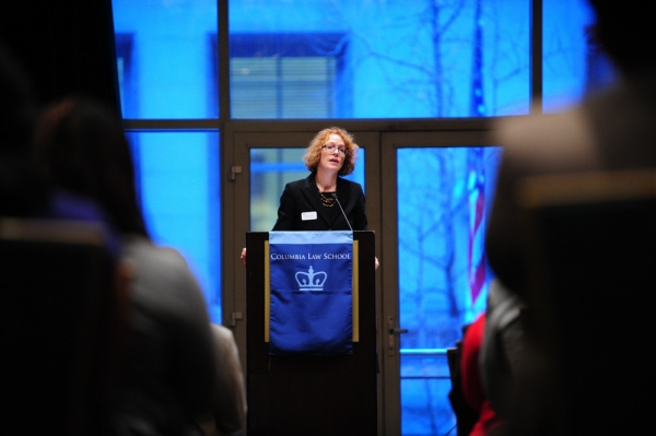 Dean Gillian Lester speaks at a podium at the Alumni of Color reception.