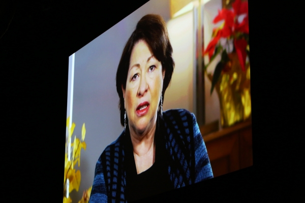 Justice Sonia Sotomayor speaking on a video screen at the Winter Luncheon