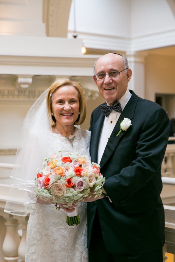  Carol Mates in a wedding dress holding a bouquet and Mark Kahan in a tuxedo