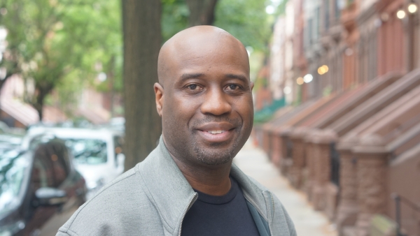 A close-up of multimedia artist Bayeté Ross Smith standing in a New York City street