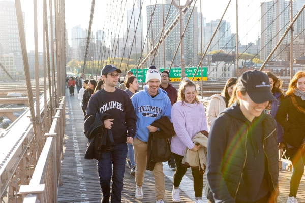 Columbia Law 1Ls are all smiles as they cross into Manhattan on the Brooklyn Bridge, led by their Contracts instructors, Professor Eric Talley and Visiting Professor Julian Arato.