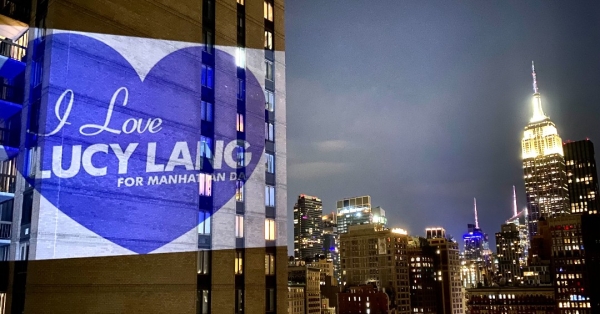 Lucy Lang campaign slogan projected on side of NYC building