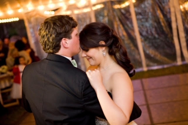  Bride with bare shoulders dancing with groom in tuxedo